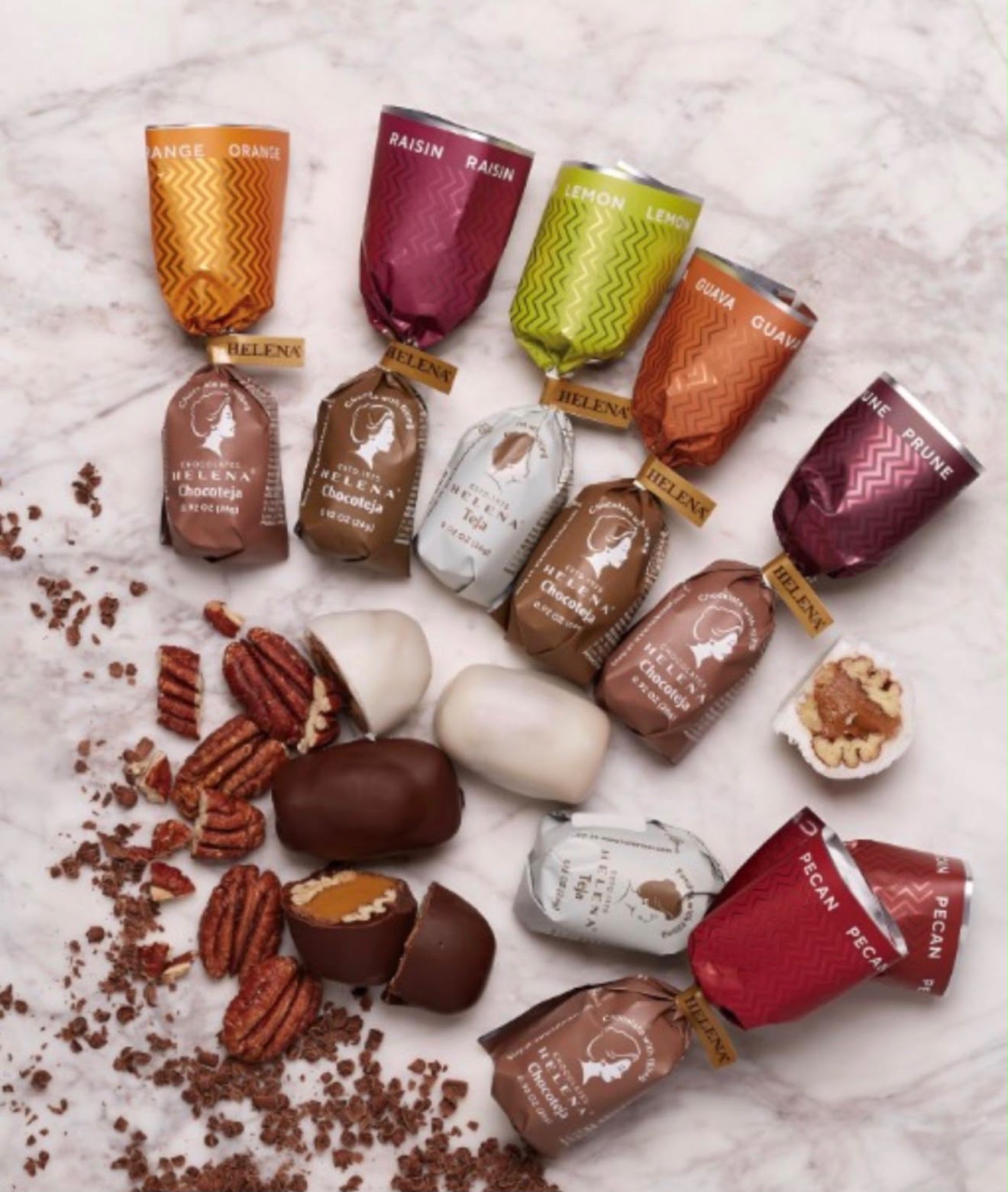 Assorted chocolate candies and nuts on a marble surface