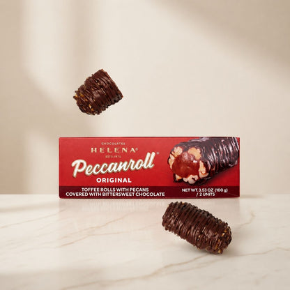Helena Peccanroll Original box with toffee rolls with pecans covered in bittersweet chocolate on marble surface
