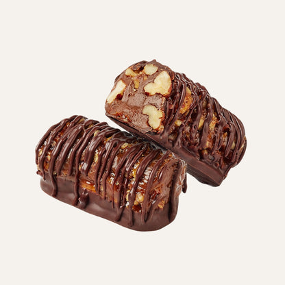 Pecanroll Toffee Bonbon whole and cut open showing pecan toffee filling covered in dark chocolate