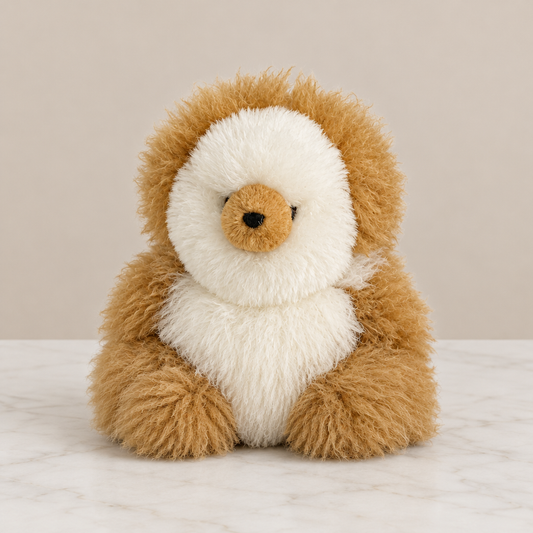 Muñeco de baby alpaca sobre mármol blanco