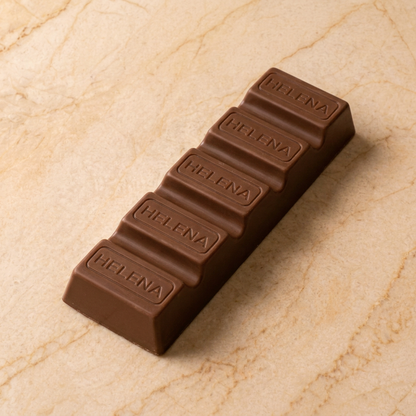 Primer plano de la barra de chocolate con leche Helena sobre mármol crema